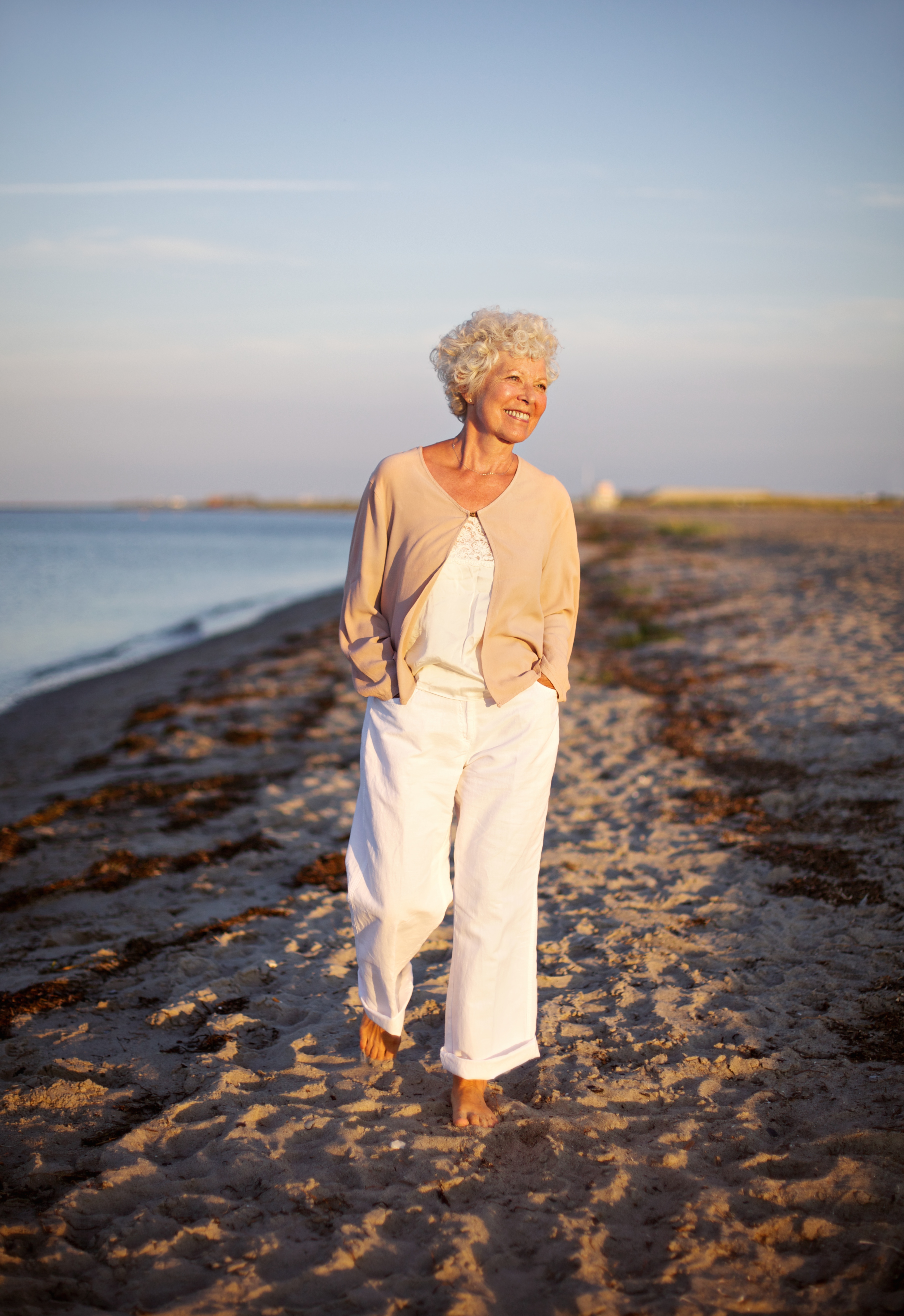 485630253 Image of senior woman walking on the beach. Happy and relaxed caucasian female strolling on the beach.