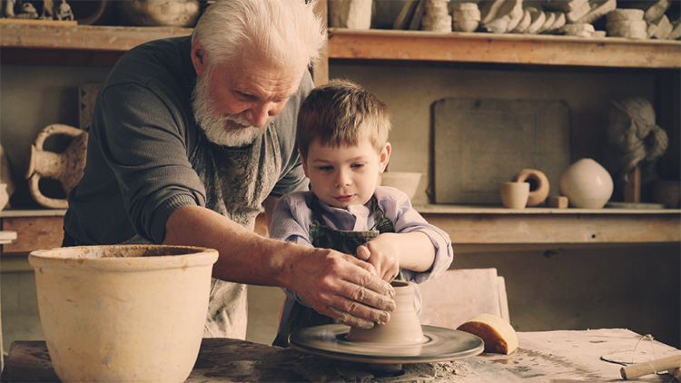 grandfather and grandson working on pottery